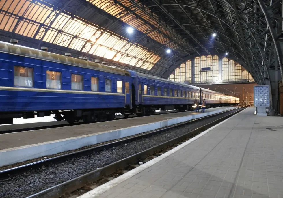 Blue passenger train under arched station roof